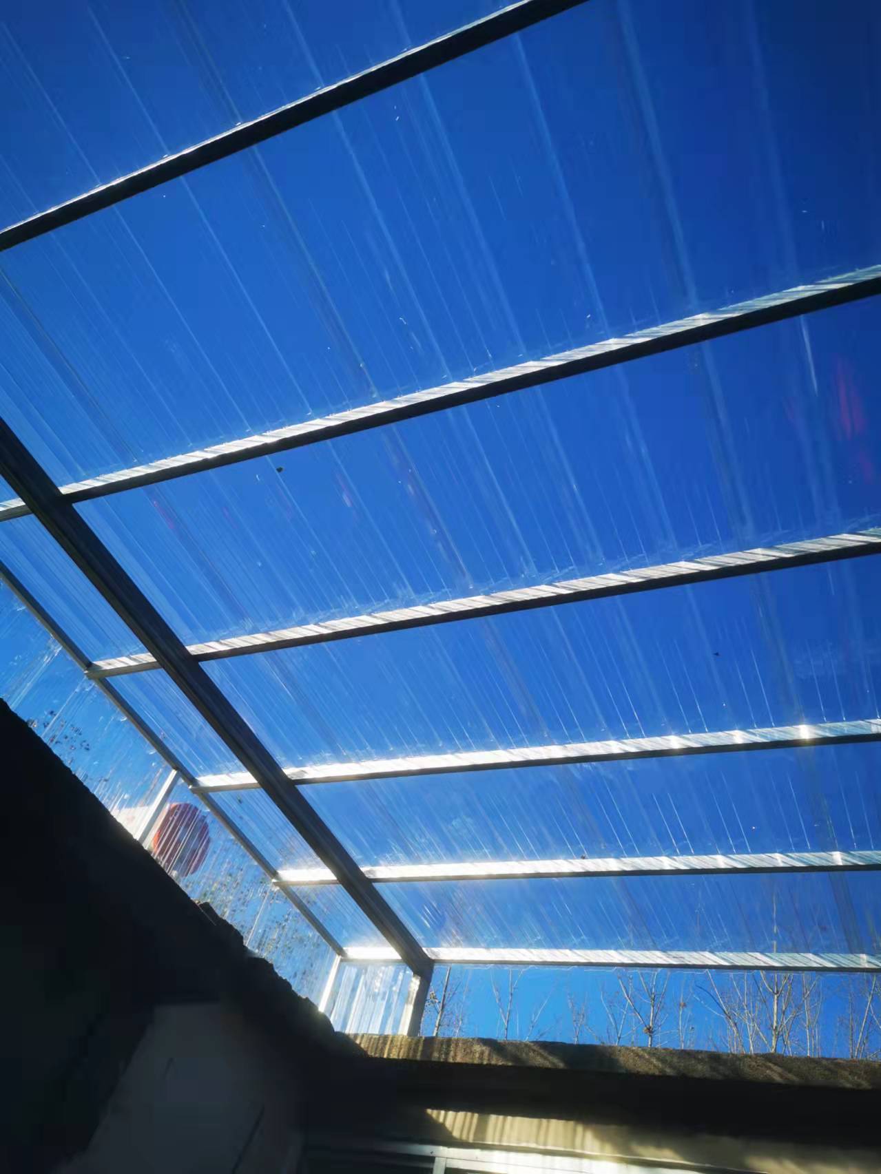 Outdoor canopy with corrugated polycarbonate roofing panels