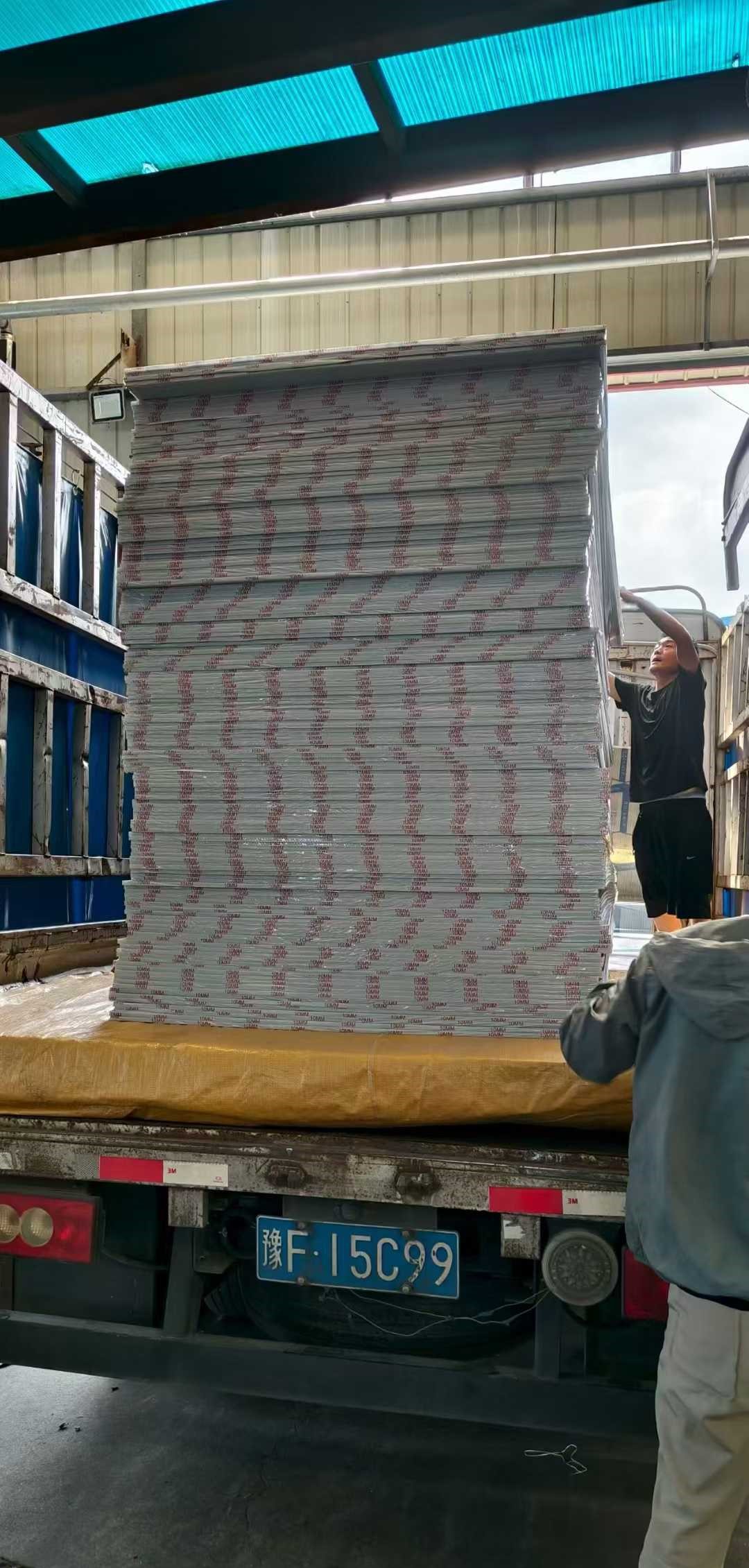 Forklift unloading polycarbonate panels from delivery truck with care