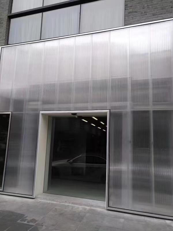 Modern commercial building facade using interlocking polycarbonate panels for a sleek translucent storefront and signage application