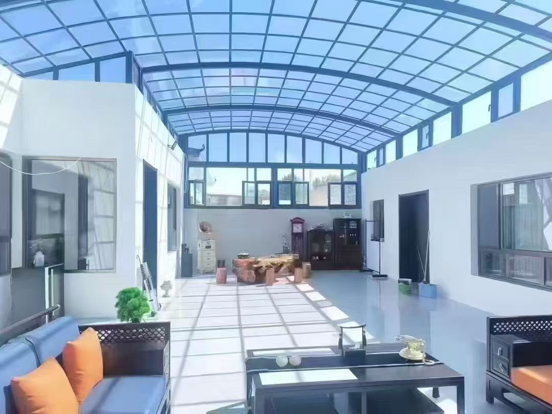 Bright interior space with arched polycarbonate roof, demonstrating natural light diffusion through solid PC sheets