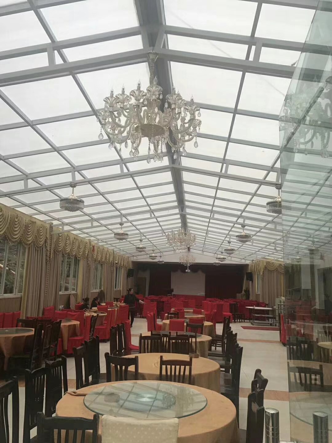 Large restaurant venue with polycarbonate sheet ceiling installation and elegant dining setup