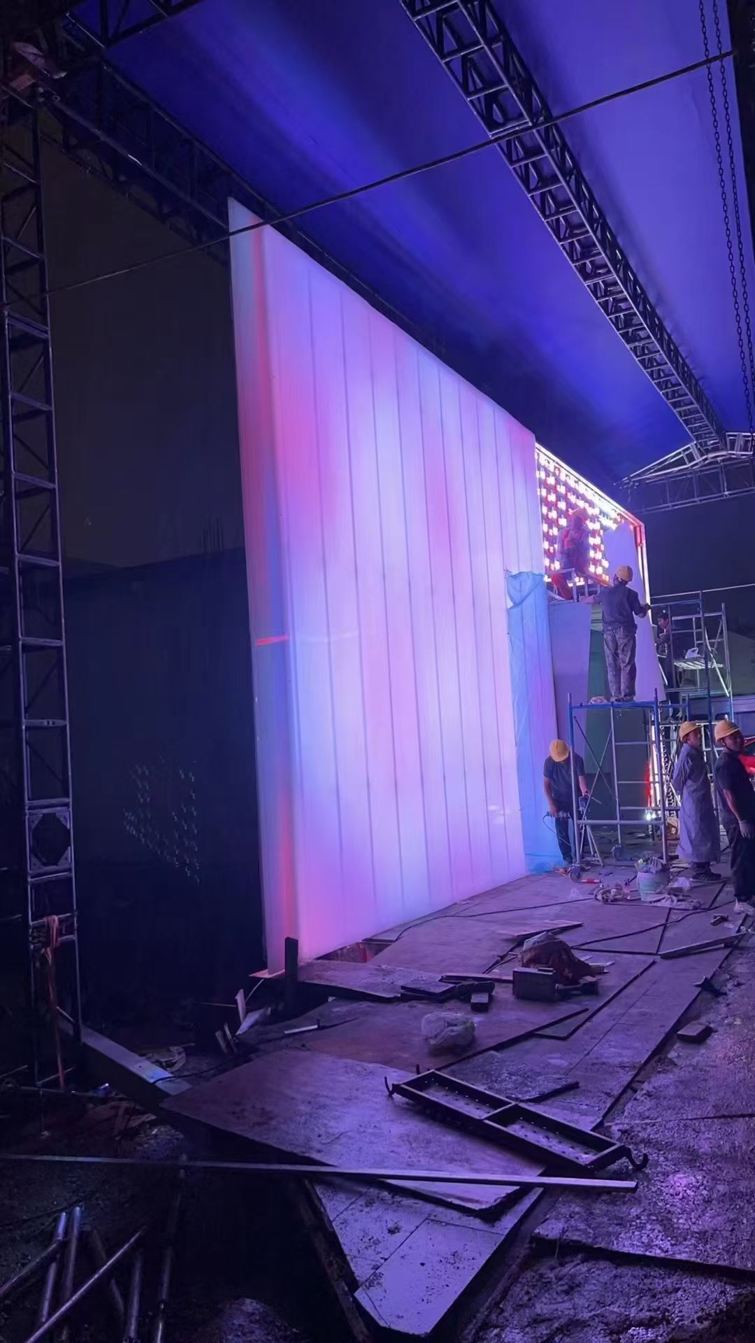 Night view of interlocking polycarbonate panel facade with dramatic LED backlighting effect