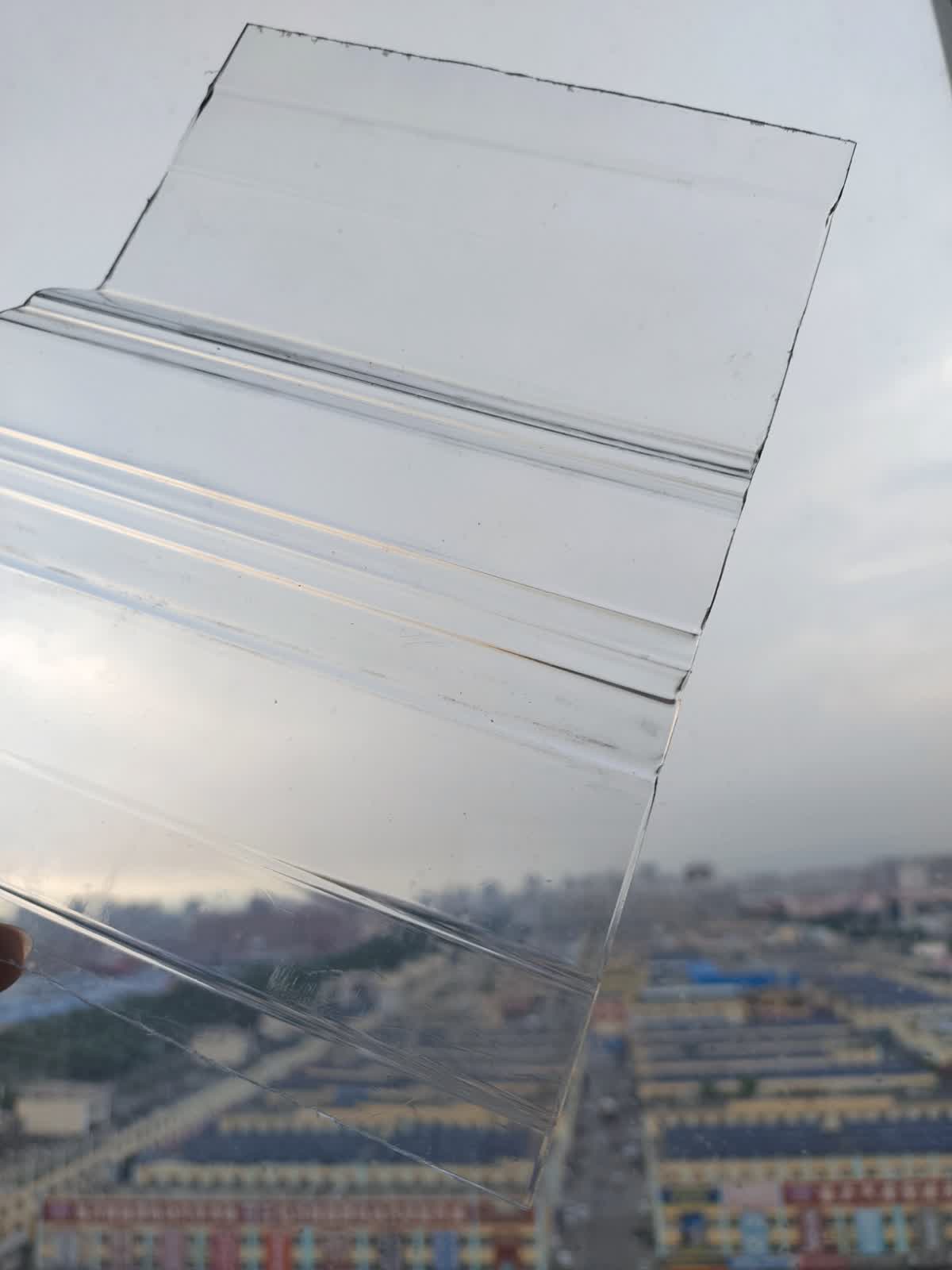Corrugated polycarbonate roofing installed on a building with city skyline visible through transparent panels