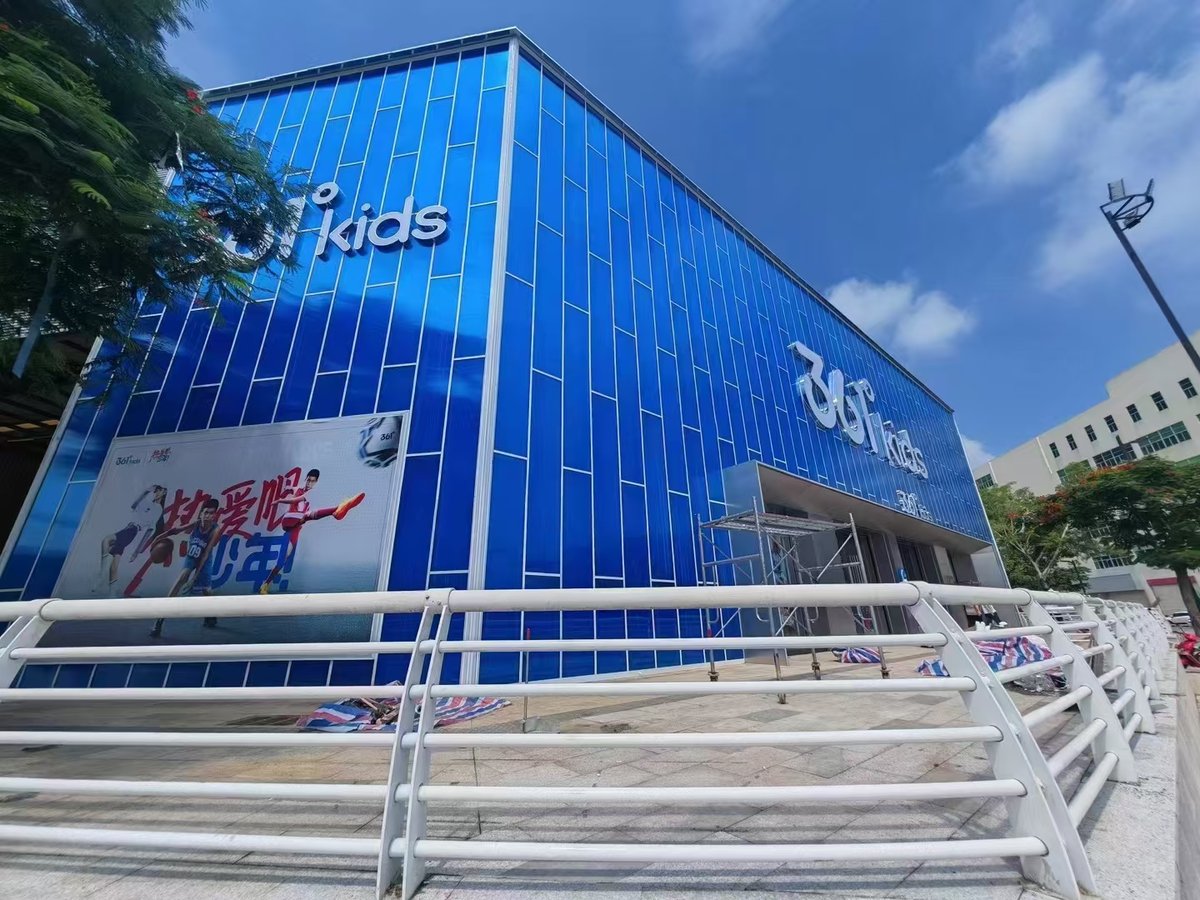 Retail storefront facade clad in blue interlocking polycarbonate panels