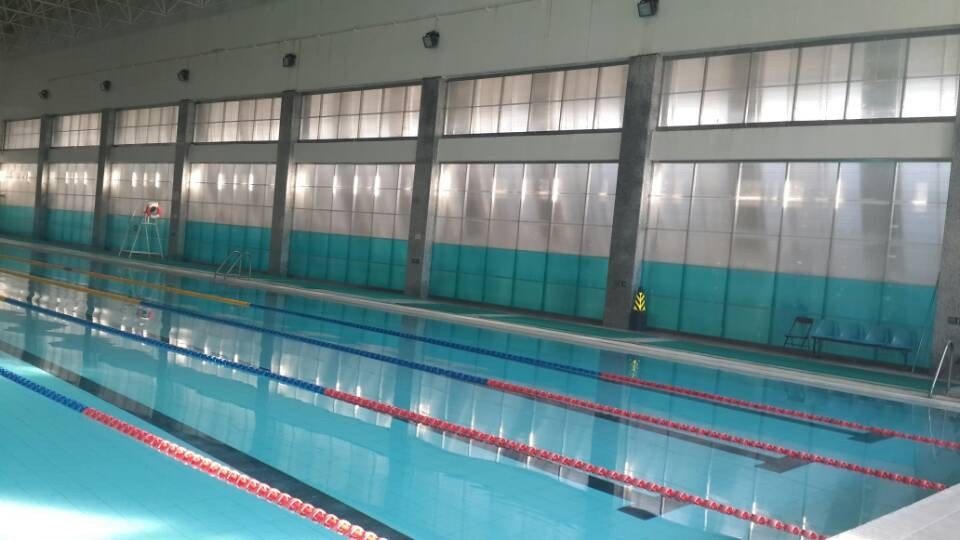 Indoor swimming pool enclosure with a translucent U-Lock polycarbonate roof providing natural daylight