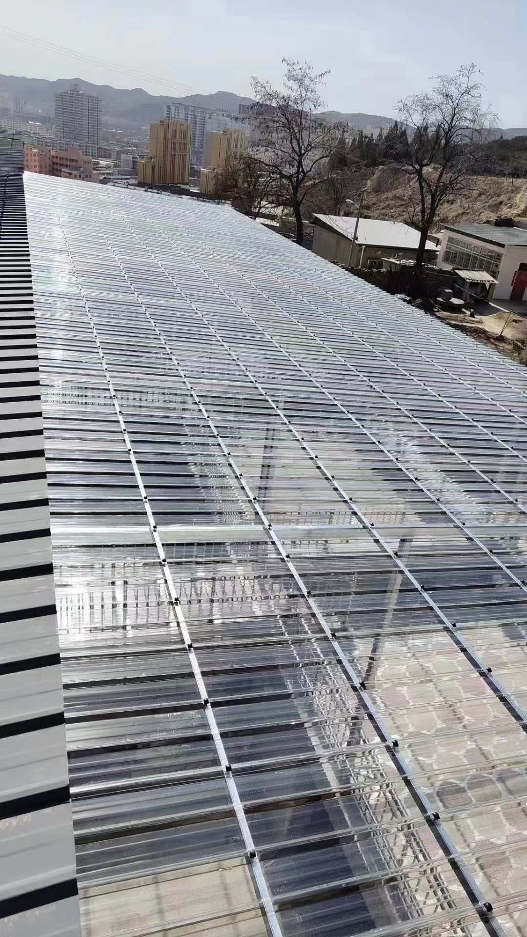 Corrugated polycarbonate daylighting sheets installed on a large sloped industrial roof