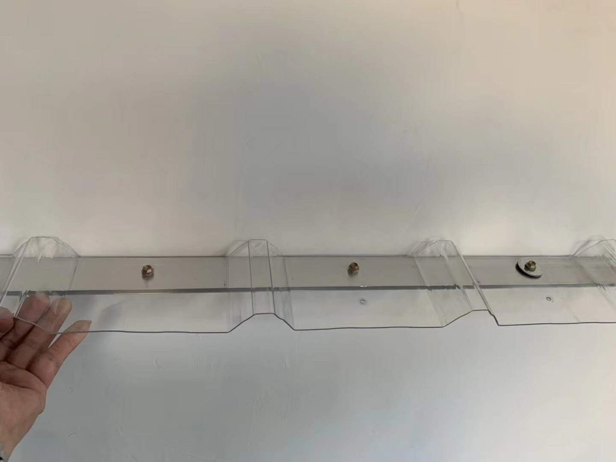 Close-up of a corrugated polycarbonate sheet fixed to a frame with screws