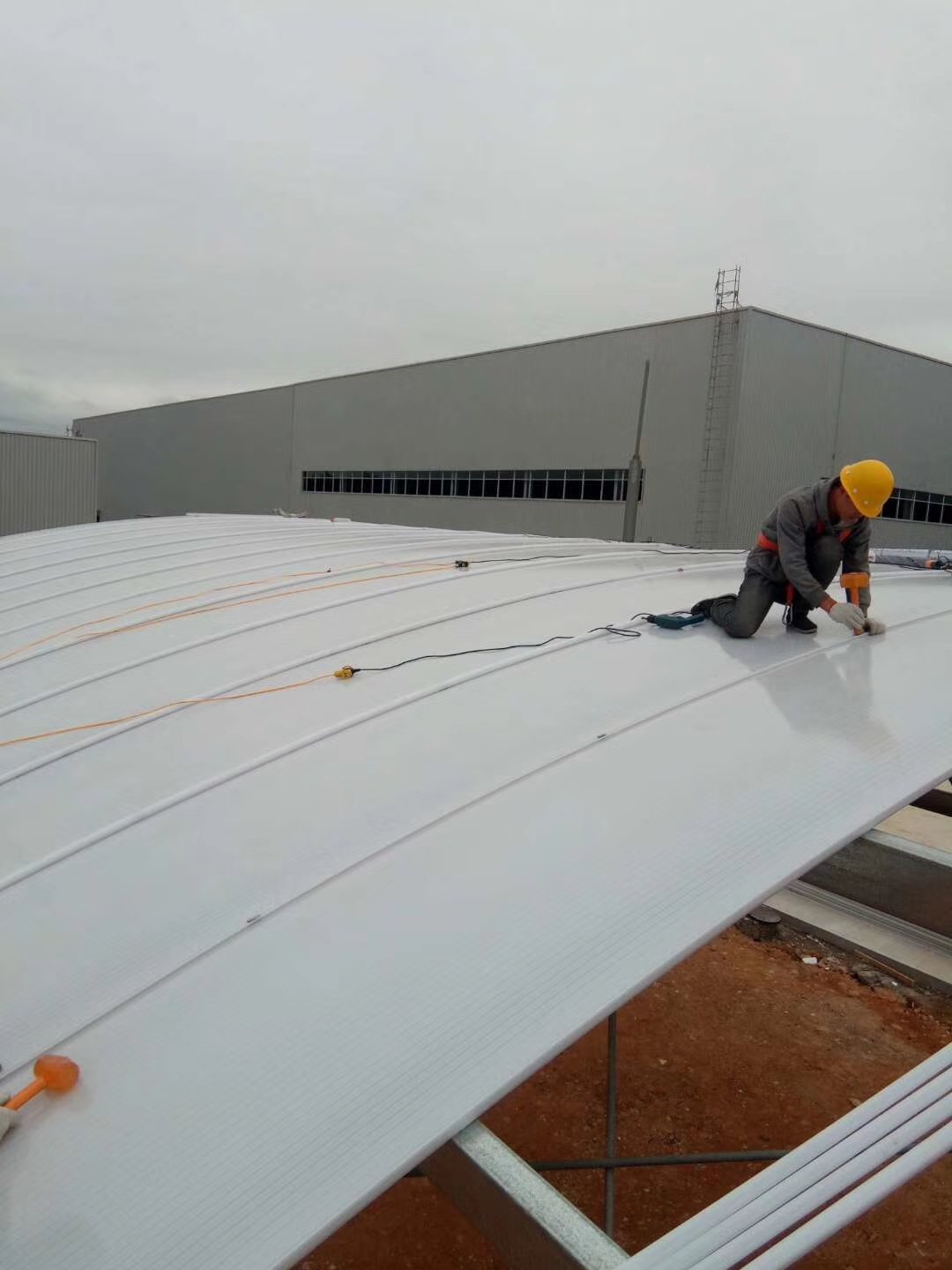 Workers installing translucent U-Lock polycarbonate panels on a factory roof skylight