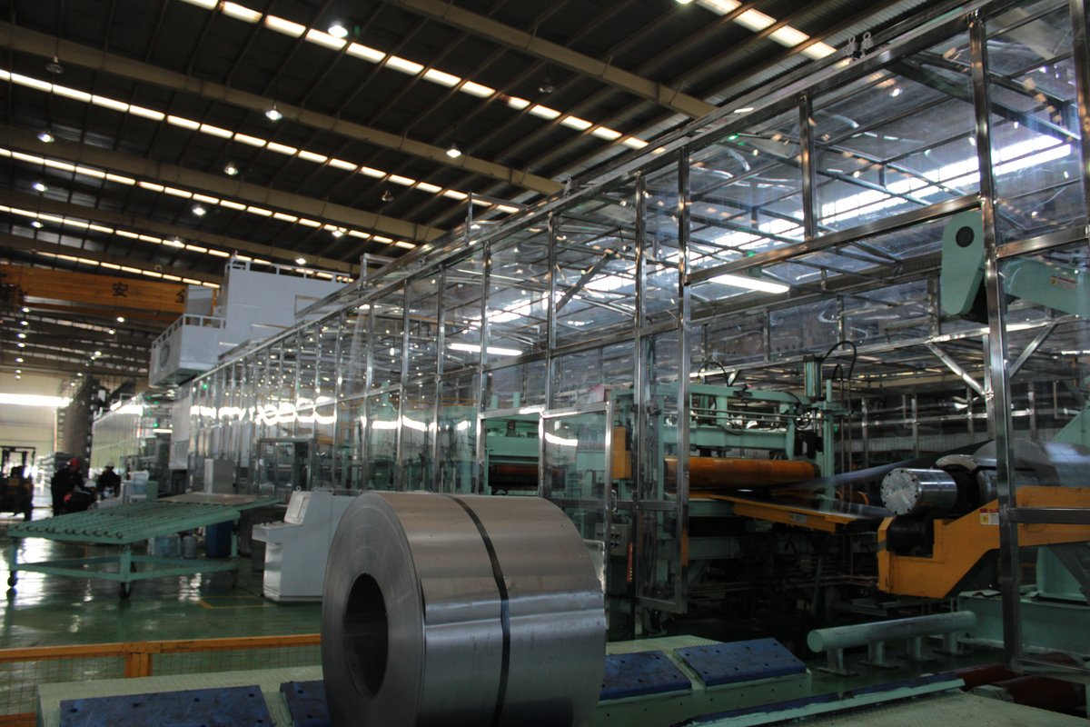 Transparent solid polycarbonate safety enclosure around a metal processing production line with overhead crane