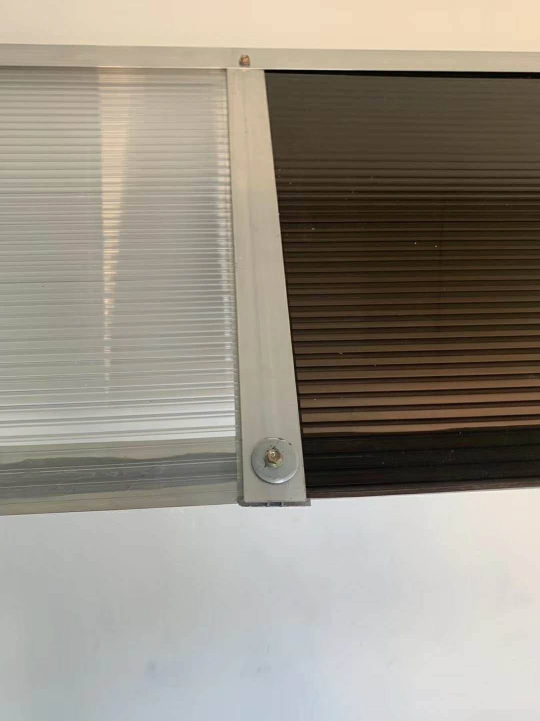 Fastening detail of a multiwall polycarbonate sheet secured with an aluminium profile and screw
