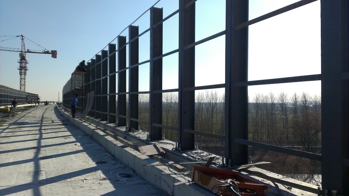 Transparent solid polycarbonate noise barrier installed along a highway
