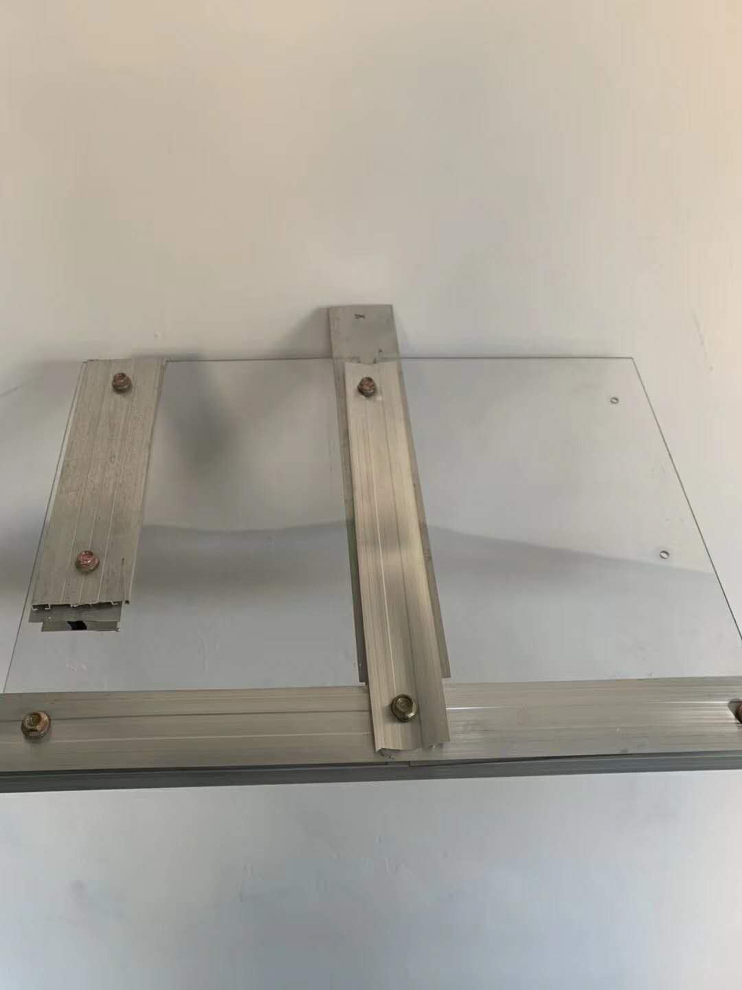 Solid polycarbonate sheet fixed to an aluminium profile with washered fasteners