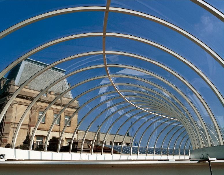 Transparent solid polycarbonate walkway light tunnel arched over a pedestrian path